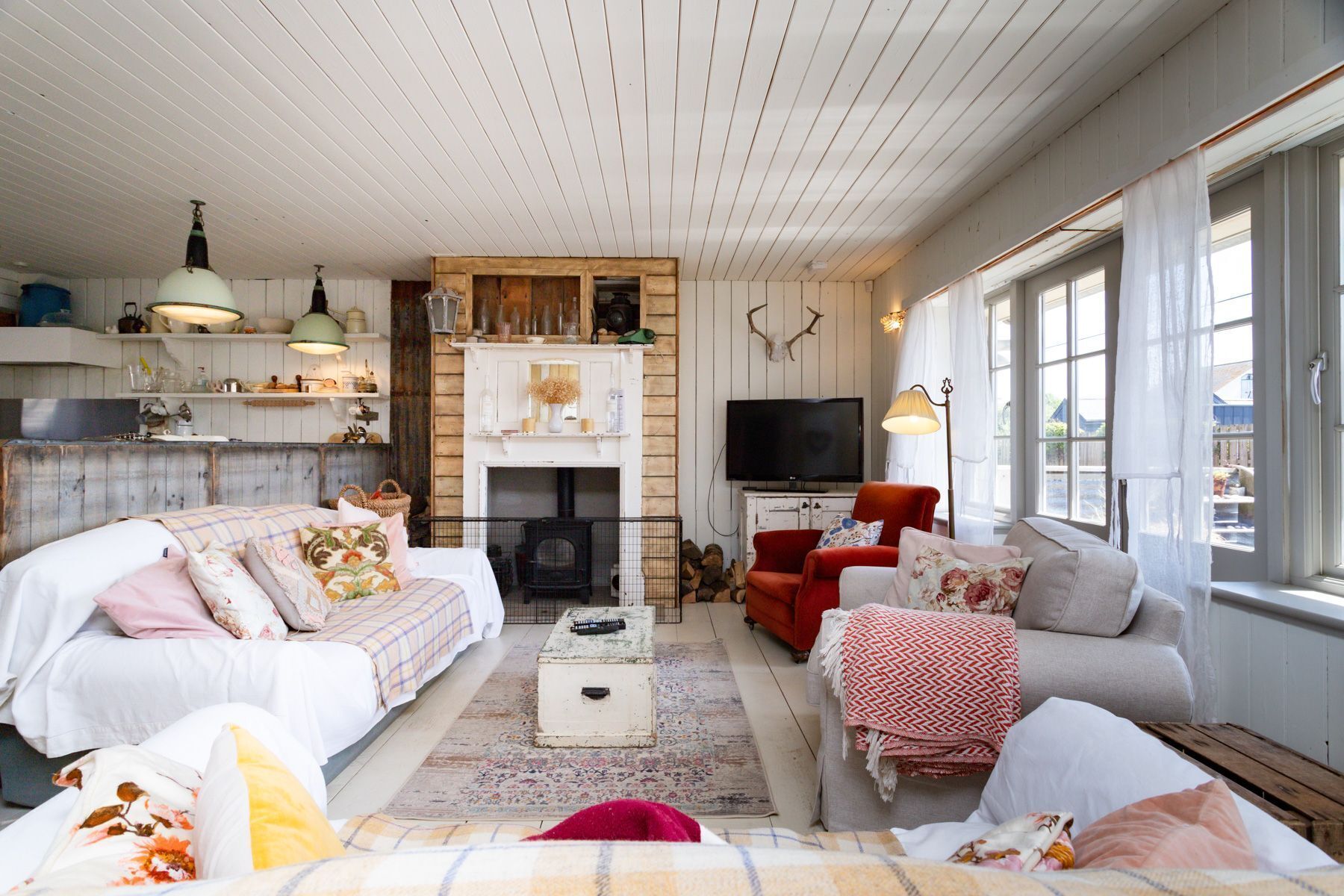 Una sala de estar acogedora con chimenea, televisor y un ventanal grande.