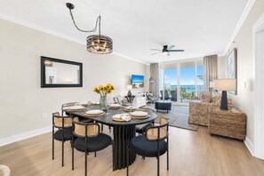 Un coin repas avec une table ronde, des chaises et un vase rempli de tournesols.