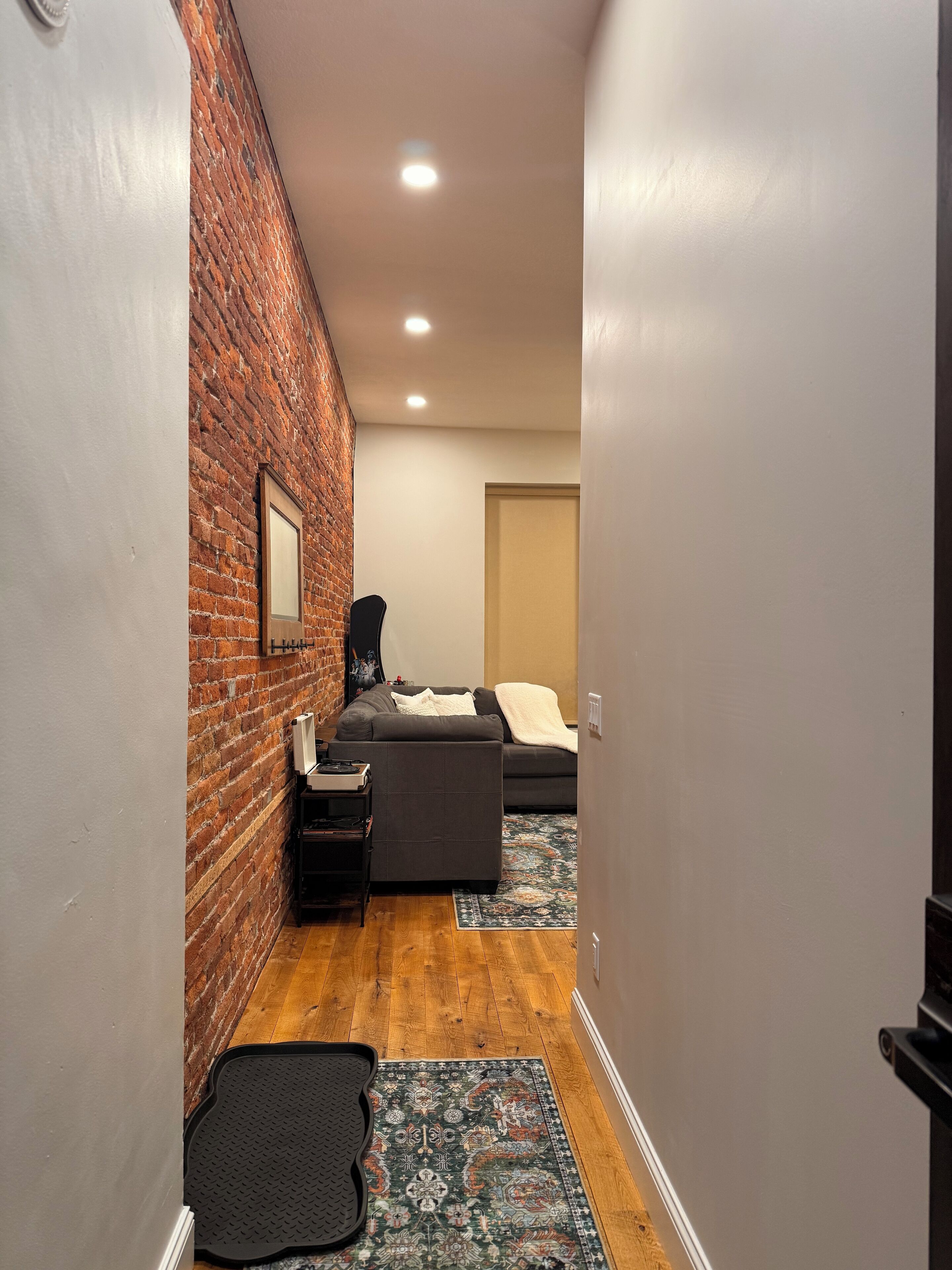 Un couloir étroit, avec un mur de briques d’un côté et un lit de l’autre.