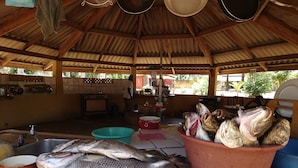 A kitchen with a large pot, a sink, and a countertop with fish. - Red Villa on Lionsrest - a tropical garden 500m from the Atlantic beach (Grand Bassam)