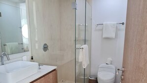 A modern bathroom with a glass-enclosed shower, a white sink, and a toilet. - Penthouse in front of Peninsula Nuevo Vallarta Beach. (Bucerías)