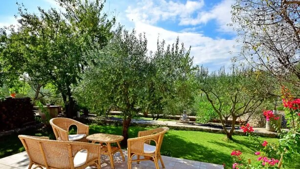 An outdoor seating area with wicker furniture and a stone-tiled patio. - Coastal Breeze House - House (Sumartin)