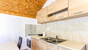 Una cucina moderna con mobili in legno, forno integrato e lavello in acciaio inossidabile.