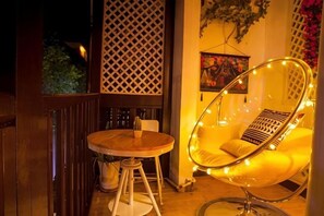 A wooden table with chairs, a hanging chair with lights, and a lattice wall. - Yangshuo Lazy People's Hall Inn (West Street Lijiang Branch) (Yangshuo)