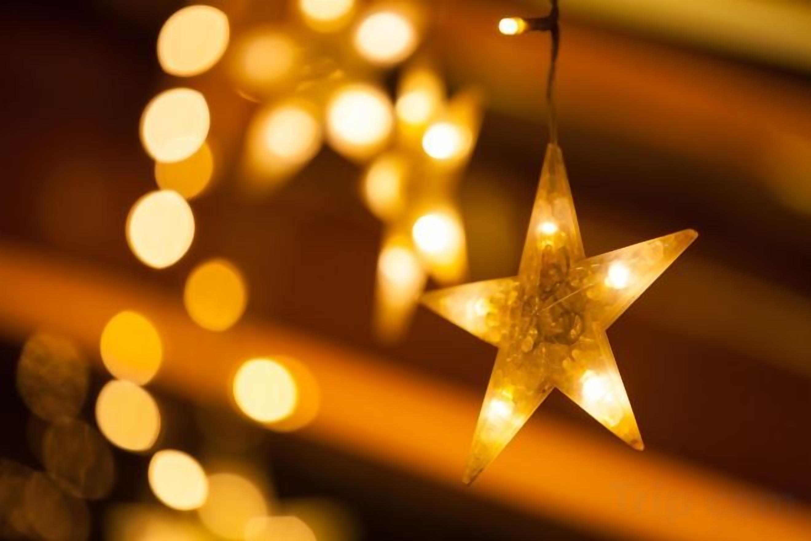 Decoración con forma de estrella y luz cálida, colgada de un hilo.