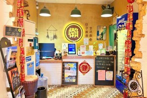 A restaurant interior with a counter, hanging lights, and various decorations. - Yangshuo Lazy People's Hall Inn (West Street Lijiang Branch) (Yangshuo)