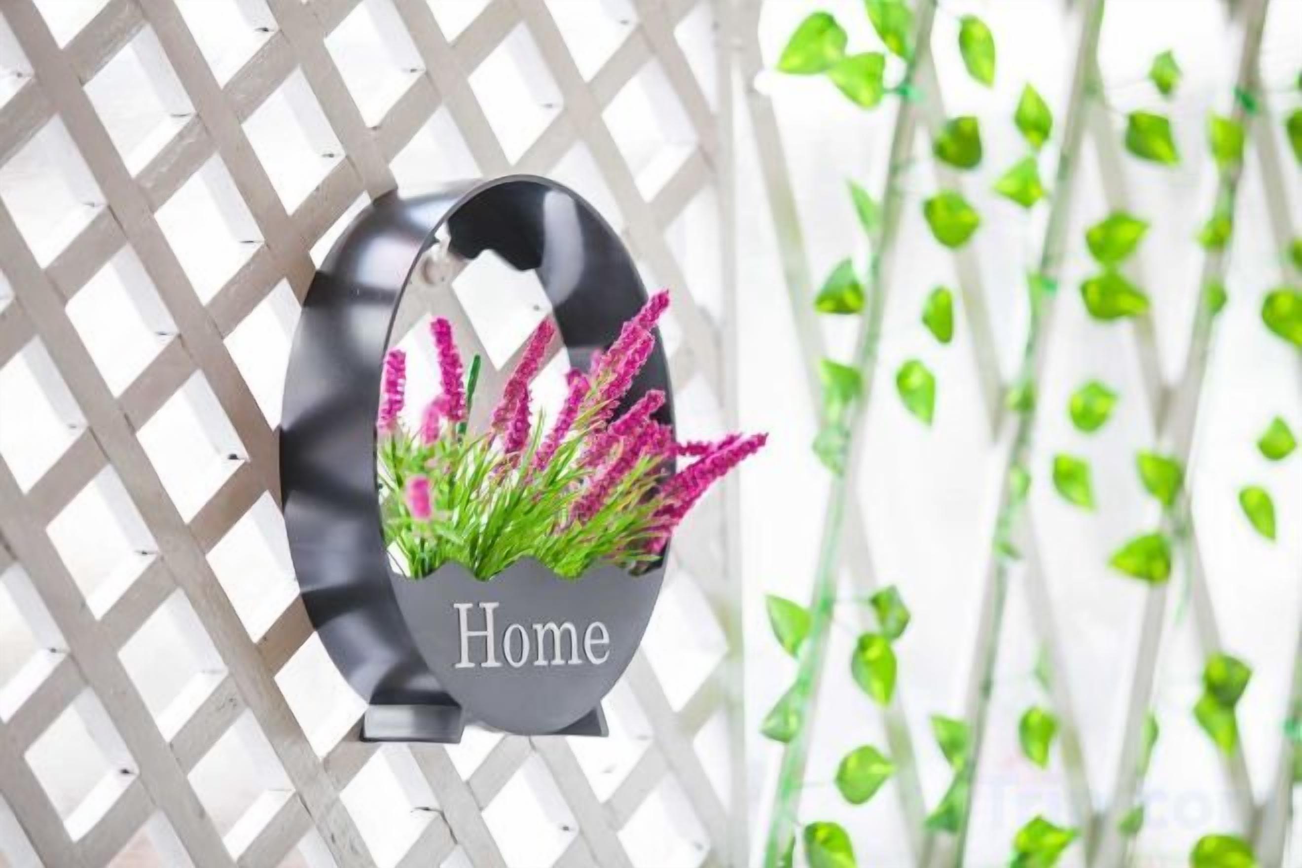 A decorative sign with the word 'Home' and a potted plant with purple flowers.