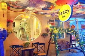 A hotel interior with a round mirror, a staircase, and a floral arrangement.