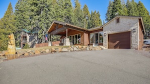 A modern house with a stone facade, large windows, and a covered porch.