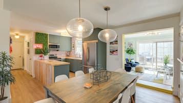 A modern kitchen with a wooden island, stainless steel appliances, and pendant lighting.