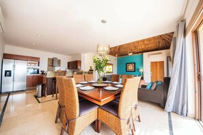 Enjoy meals in the dining area with a wooden table and wicker chairs.