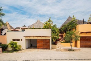 Set amidst lush greenery and palm trees, this two-story residence offers a tranquil retreat.