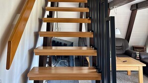 A wooden staircase with a door at the top, leading to an upper level. - Pure nature - forest vacation in a tiny house (Ronshausen)
