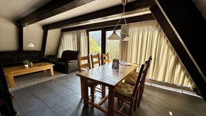 A dining area with a wooden table and chairs, a sofa, and a bench. - Pure nature - forest vacation in a tiny house (Ronshausen)