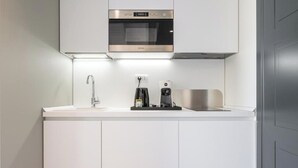 A modern kitchen with a built-in oven, a coffee machine, and a sink. - Deluxe Double Room (Cagliari)