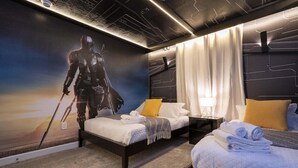 A bedroom with a Star Wars-themed mural, a bed with a white comforter, a bedside table with a lamp, and a nightstand with a lamp.