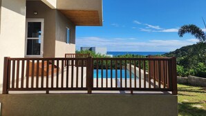 Um edifício moderno de dois andares com varanda de madeira e piscina.
