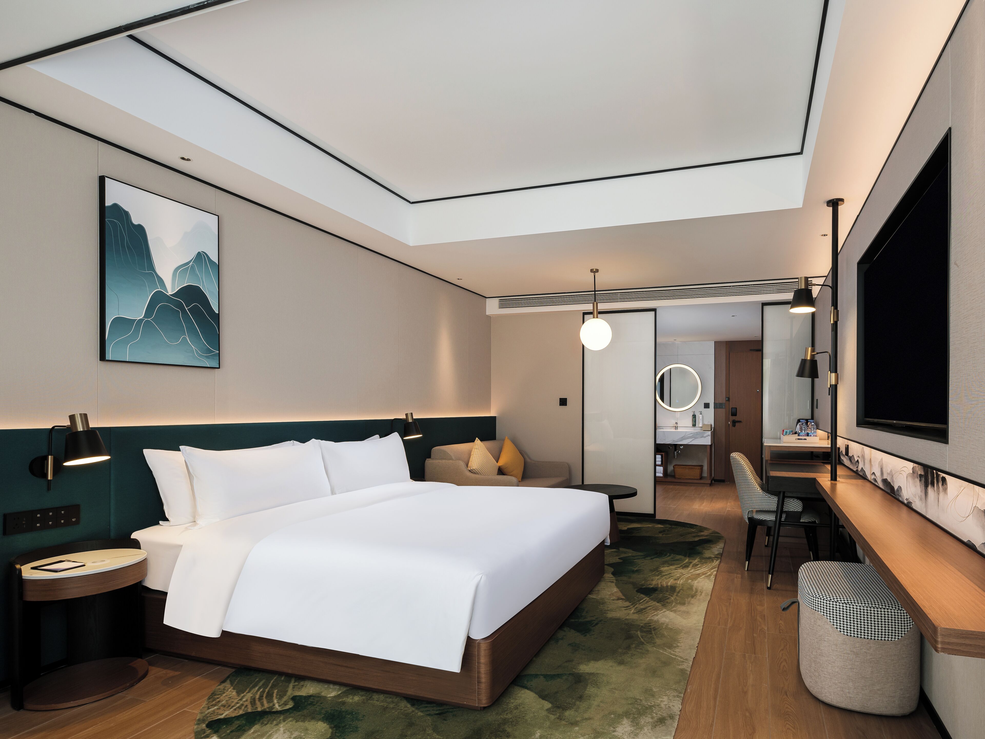 Una habitación de hotel moderna con una cama grande, mesitas de noche, un escritorio y una zona de estar.