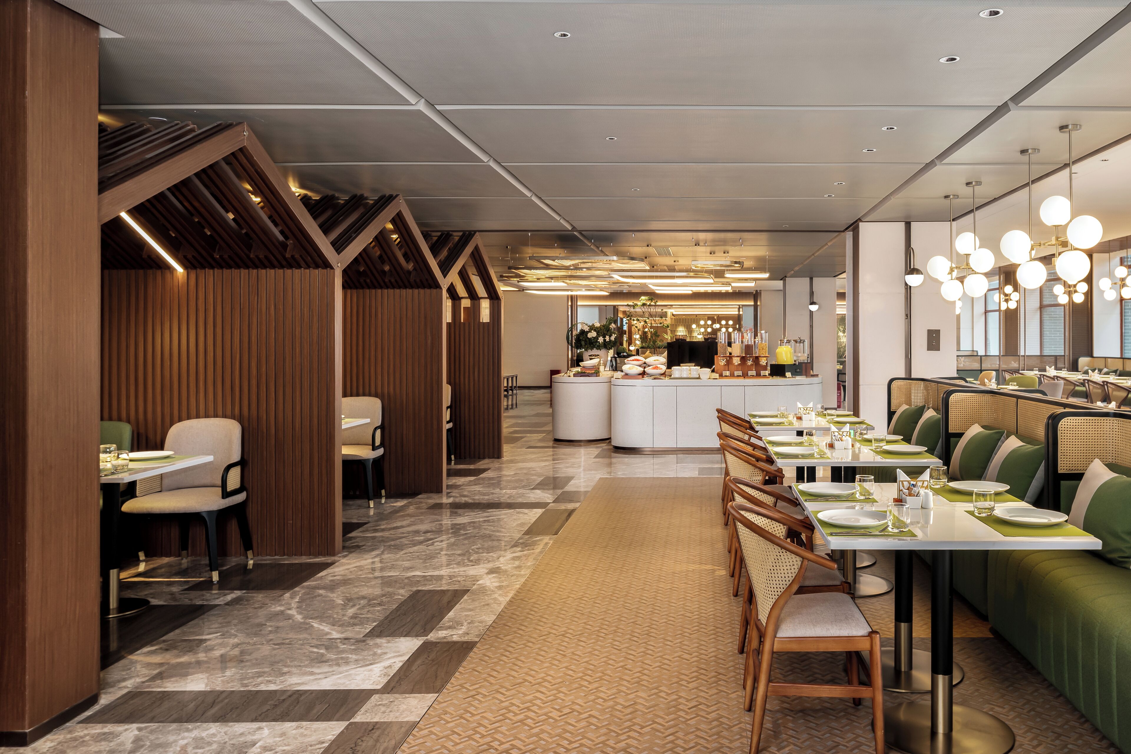 A modern restaurant with a long counter, booths, and a central island.