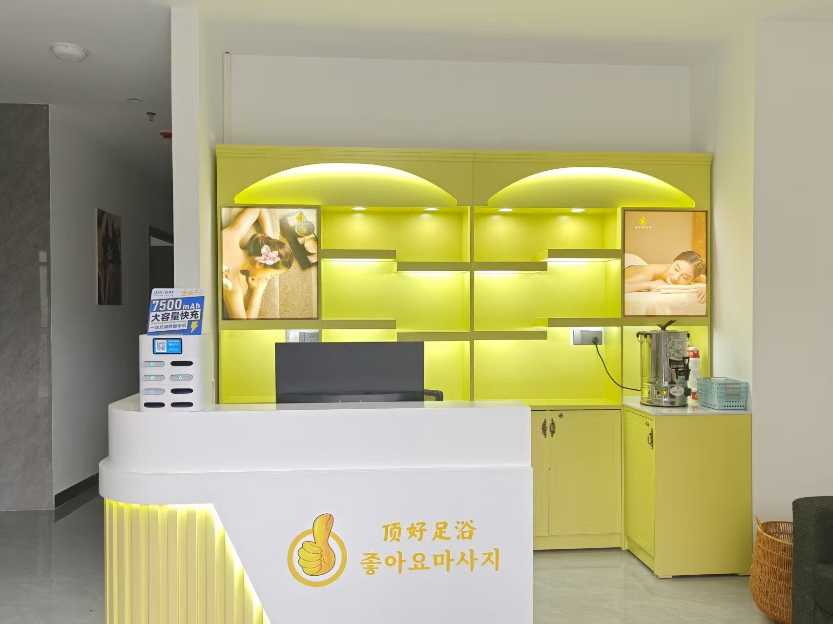A reception desk with a sign indicating a 7500mAh battery capacity, a digital display, and a logo.