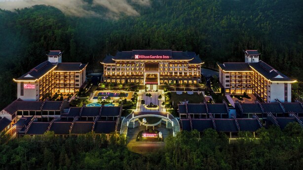 A large hotel with multiple buildings, a central entrance, and a surrounding pool area. - Hilton Garden Inn Zhangjiajie Wulingyuan (Zhangjiajie)