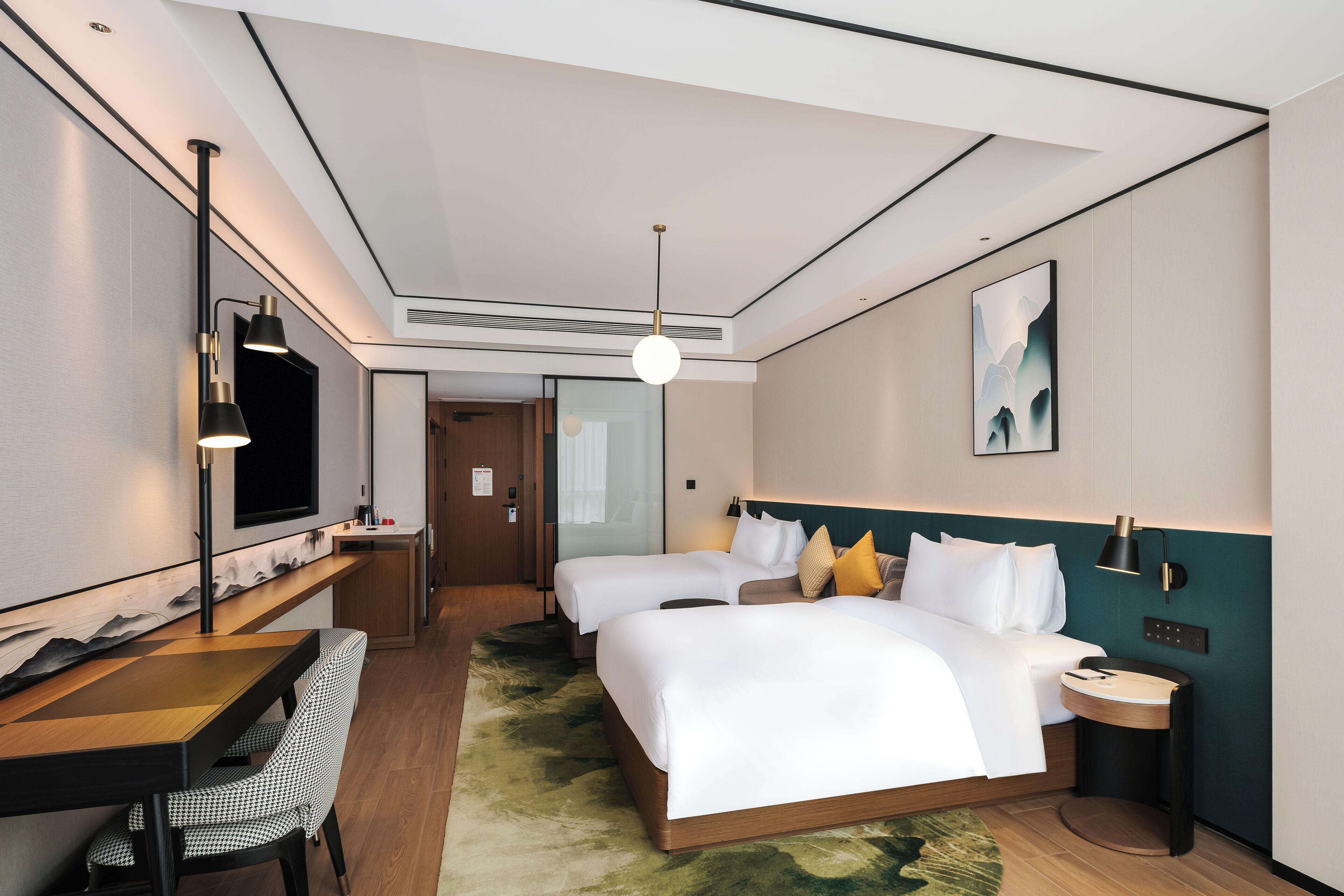 A hotel room with a large bed, a desk with a chair, a TV, and a painting on the wall.