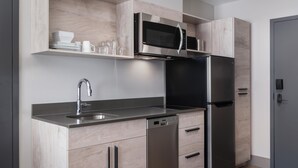 Una cocina moderna con refrigerador, lavavajillas y microondas de acero inoxidable.