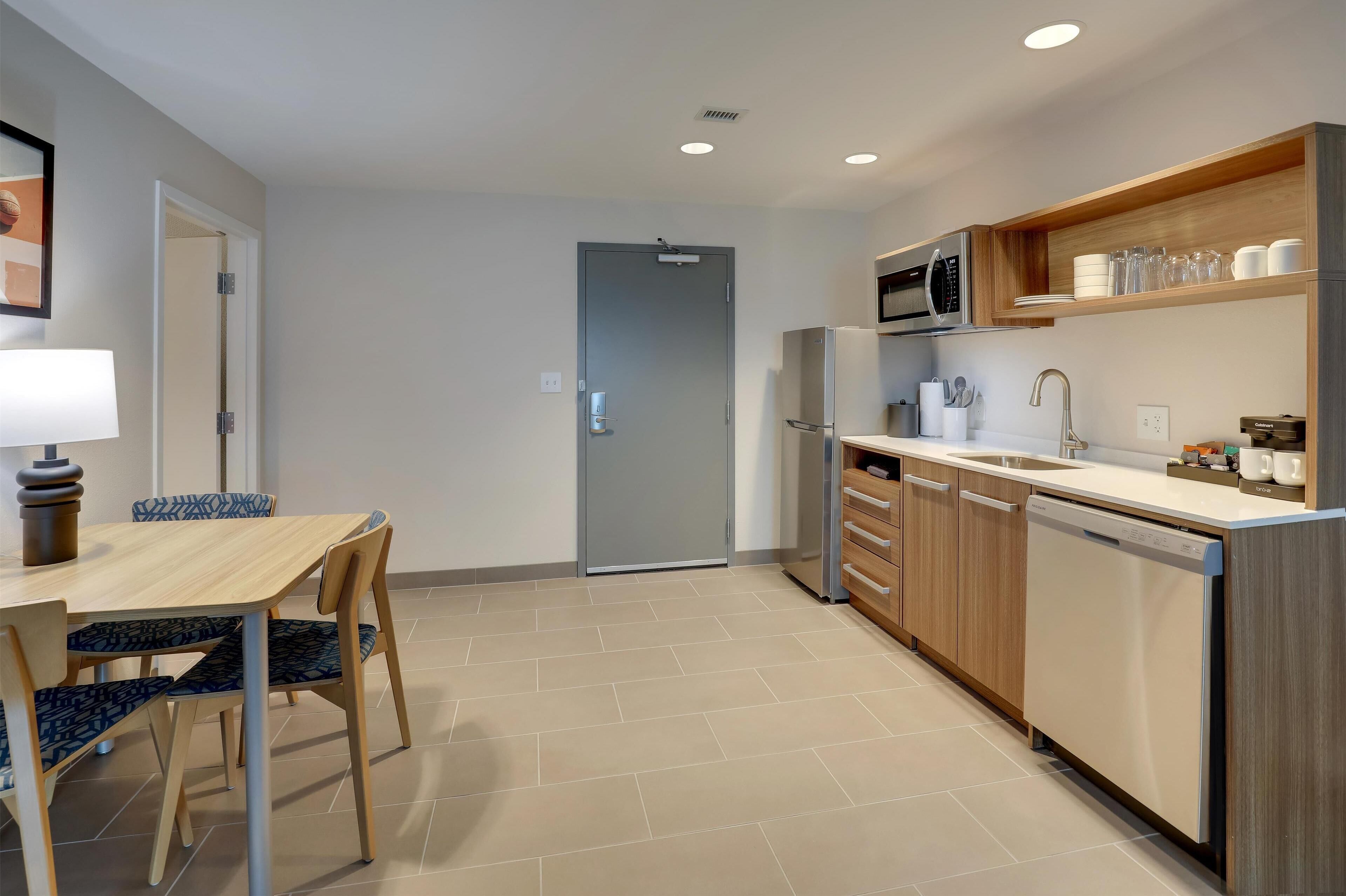 A modern kitchen with wooden cabinets, a built-in microwave, and a dishwasher.