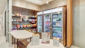 A snack bar with a white table and two display stands labeled "Yummies" and "Treats." - Home2 Suites By Hilton Crestview I-10 (Crestview)