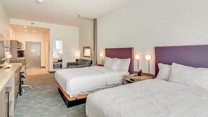 A hotel room with two beds, a desk with a chair, a mirror, a wardrobe, and a bathroom visible through an open door. - Home2 Suites By Hilton Crestview I-10 (Crestview)
