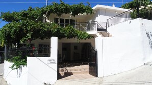 A two-story building with a white exterior, a balcony, and a staircase leading to the upper floor. - Aggeliki House Jetted Tub, Vasiliki & Aggeliki (Rethymno)