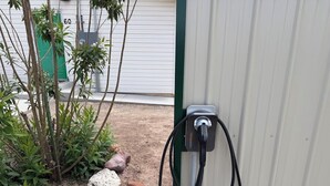 Uma estação de carregamento portátil para veículos elétricos fixada a uma parede de metal.
