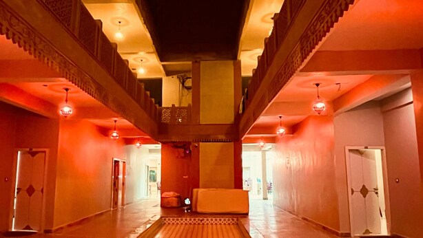 A spacious, well-lit hallway with patterned flooring, a central open area, and multiple doors leading to rooms. - siyavar palace (Orchha)