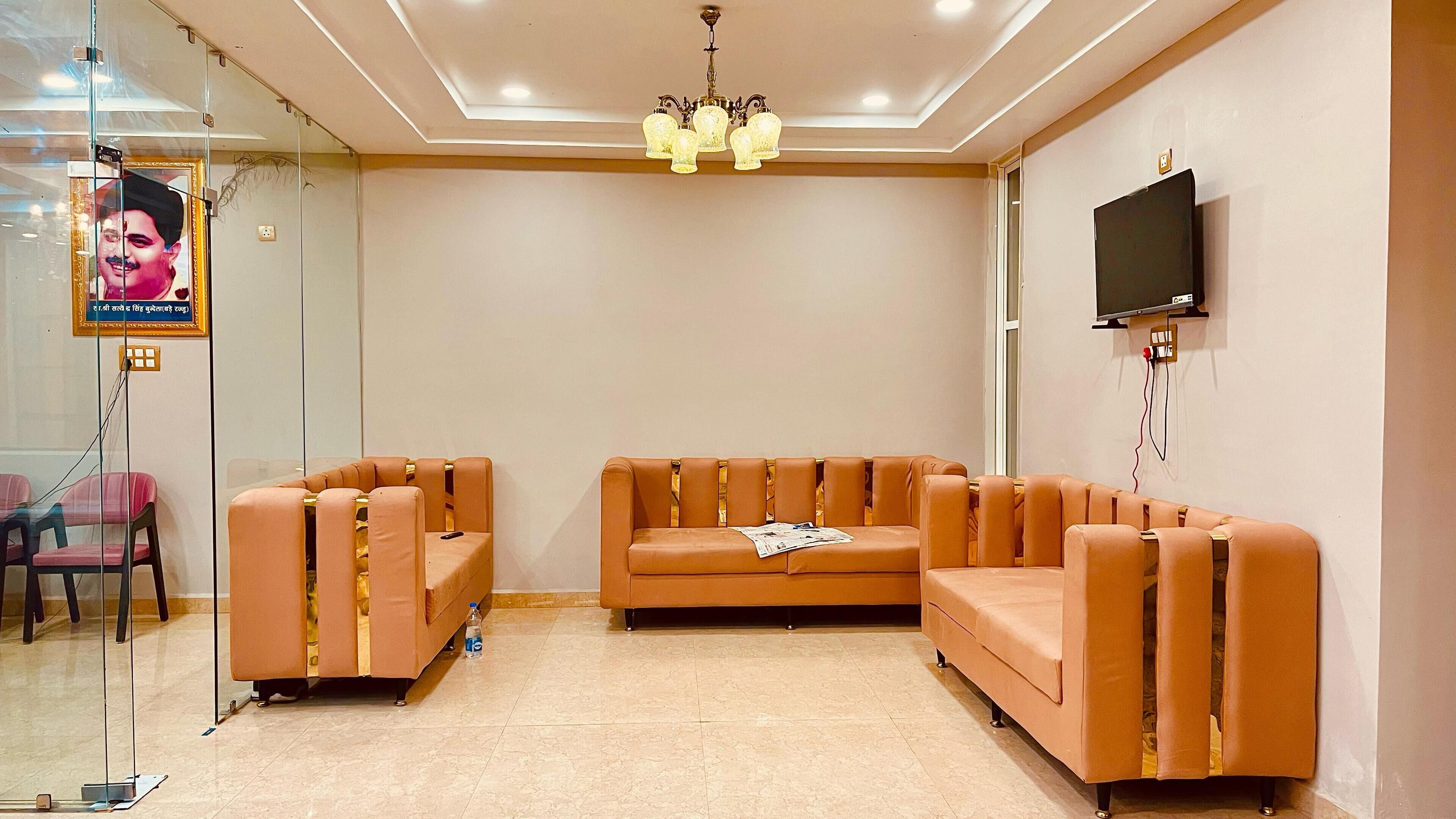 A modern waiting area with a sectional sofa, a glass partition, and a mounted television.