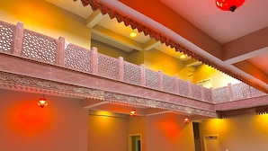 A multi-level interior with ornate railings and warm lighting. - siyavar palace (Orchha)