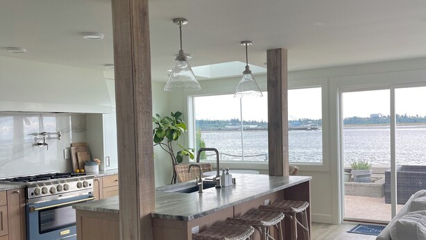 A modern kitchen with a central island, bar stools, and a view of a body of water. - Luxury 4BR Beachfront Retreat. Designer Kitchen, Views, Game Room, Piano, A/C (Tulalip Bay)