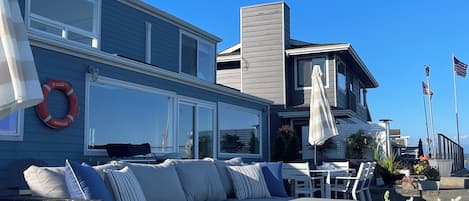 A residential property with a large outdoor seating area, a pool, and a lifebuoy.