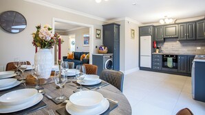 A modern kitchen with grey cabinets, a built-in oven, and a dishwasher. - No 31 Killarney Holiday Village for 8! Ideal Location! (Killarney)
