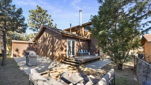 A cabin with a deck, outdoor seating, and a grill. - Lincoln Log Cabin | Renovated | Near Attractions (Big Bear)