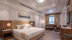 Une chambre d’hôtel avec un grand lit, un bureau, une chaise, une télévision et un tableau au mur.
