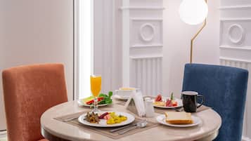 A breakfast setting with a table, chairs, and a lamp.