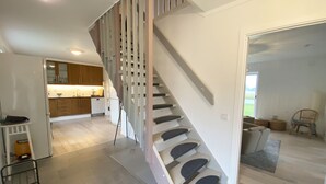 Een modern interieur met een trap, een keuken en een zithoek.