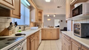 A kitchen with wooden cabinets, a central island, a microwave, and a built-in oven.