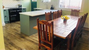 Una cocina con armarios de madera, una isla central y una mesa de comedor con sillas.