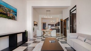 A modern living room with a sofa, a coffee table, and a TV on the wall. - Soho House – Inspired by RH (San Juan)