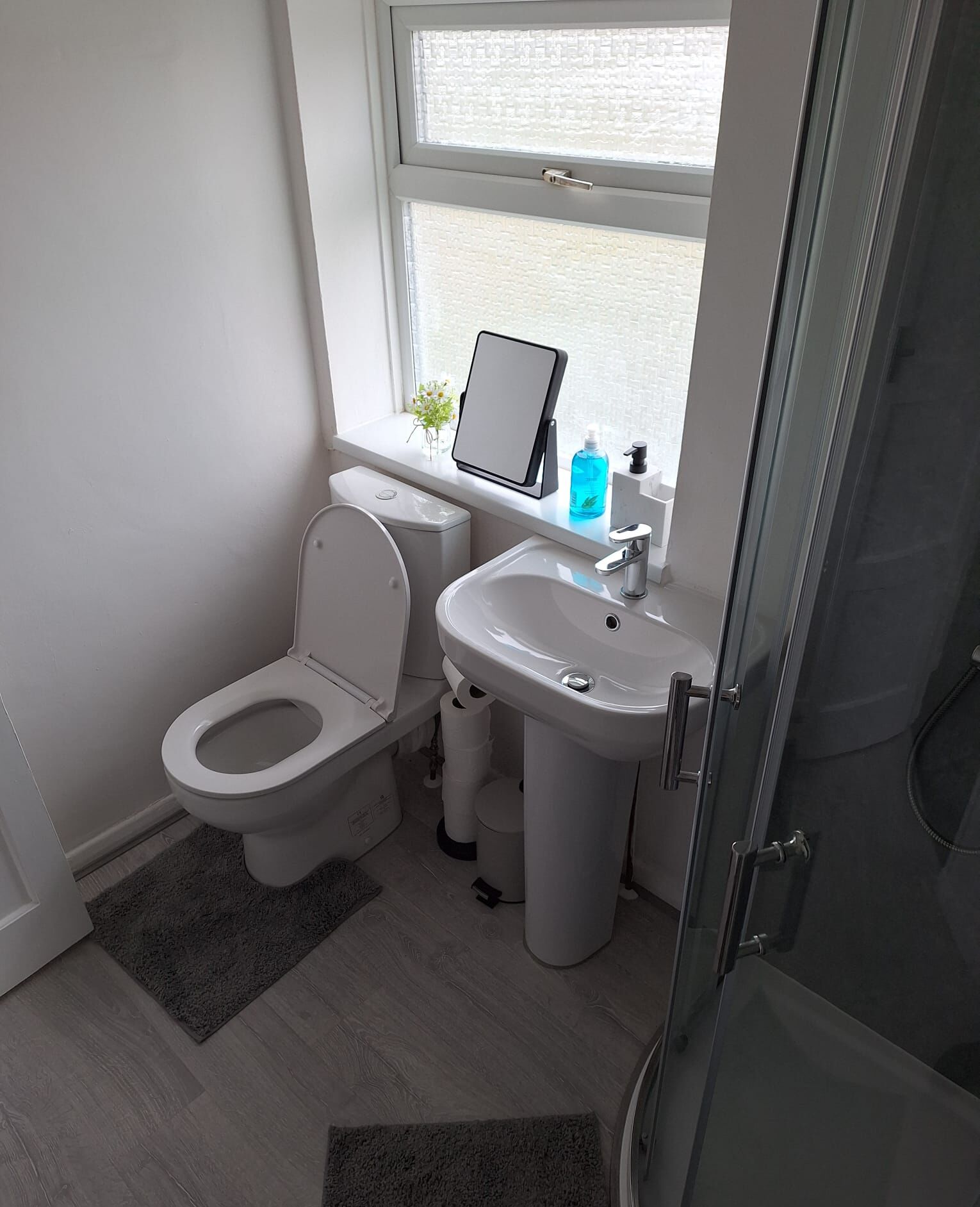 A modern bathroom with a toilet, sink, and shower.