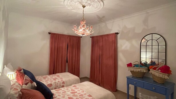 A bedroom with two beds, a chandelier, a mirror, and a small table. - Summer Villa With Heated Private Pool (Faro)