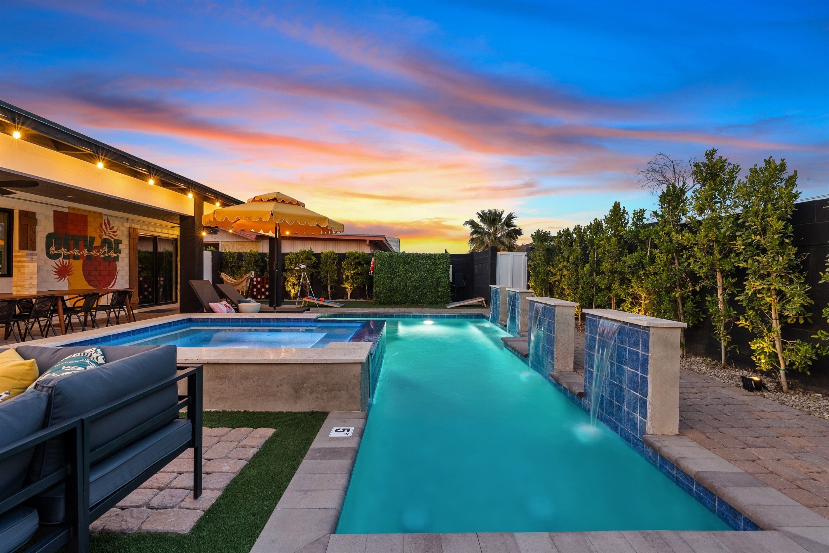 Zona de piscina con vistas al atardecer, un restaurante y mobiliario exterior.
