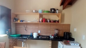 Una cocina compacta con armarios de madera, una encimera y un refrigerador pequeño.