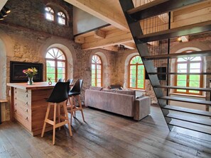 A rustic interior with a wooden bar, seating area, and large windows.